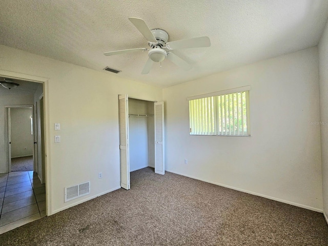 unfurnished bedroom featuring carpet, ceiling fan, a textured ceiling, and a closet