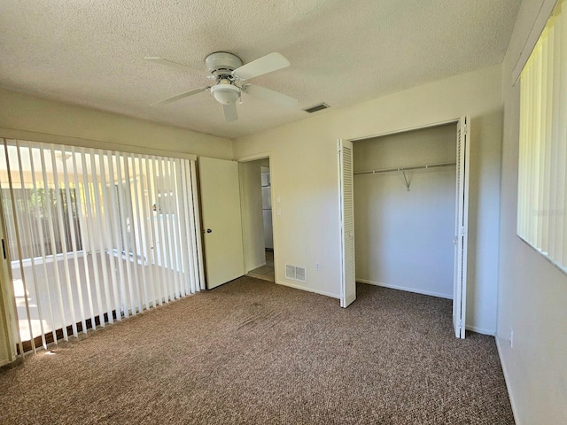 unfurnished bedroom featuring ceiling fan, carpet floors, a textured ceiling, and a closet