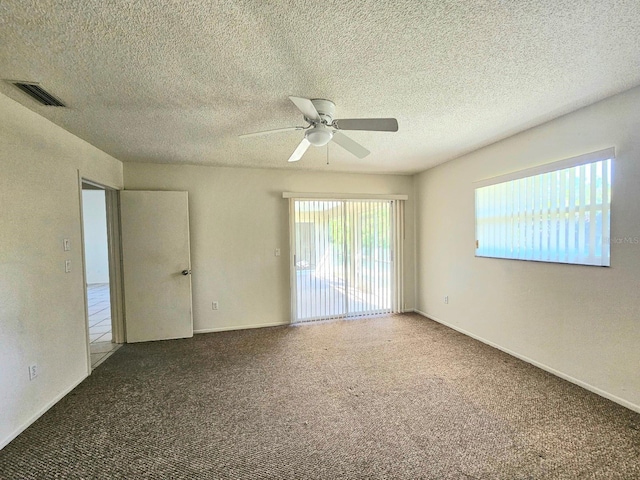 empty room featuring ceiling fan, carpet floors, and a textured ceiling