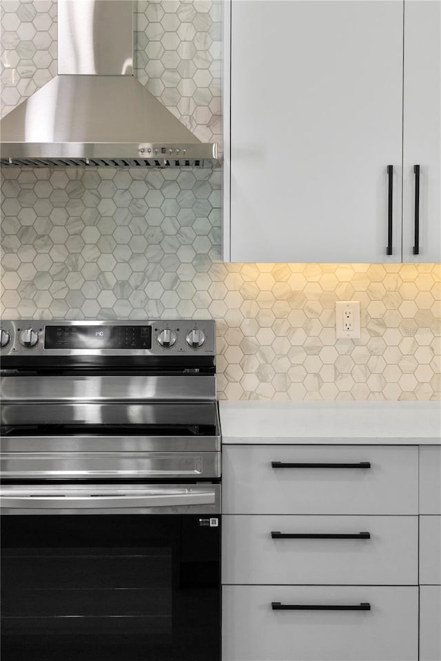 kitchen with backsplash, white cabinetry, wall chimney exhaust hood, and stainless steel electric range