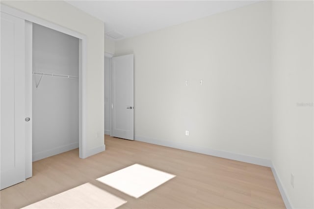 unfurnished bedroom with light hardwood / wood-style floors and a closet