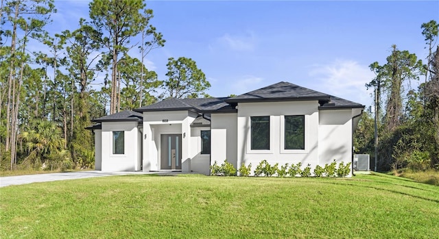 view of front of home with a front yard and central AC unit