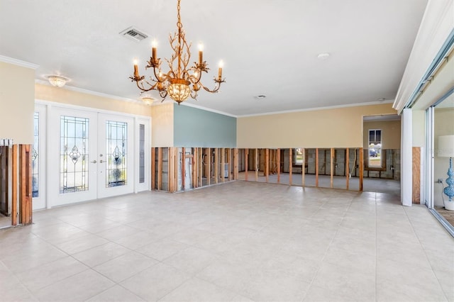 spare room featuring a notable chandelier, crown molding, and french doors