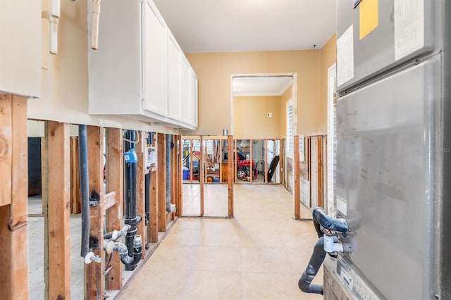 interior space with crown molding and light tile patterned flooring