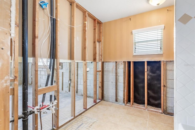 misc room featuring light tile patterned floors and tile walls