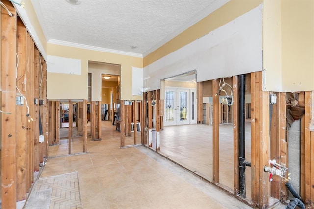 interior space with french doors, a textured ceiling, light tile patterned floors, and crown molding