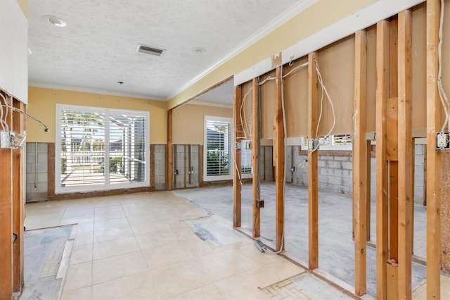 misc room with a textured ceiling and ornamental molding