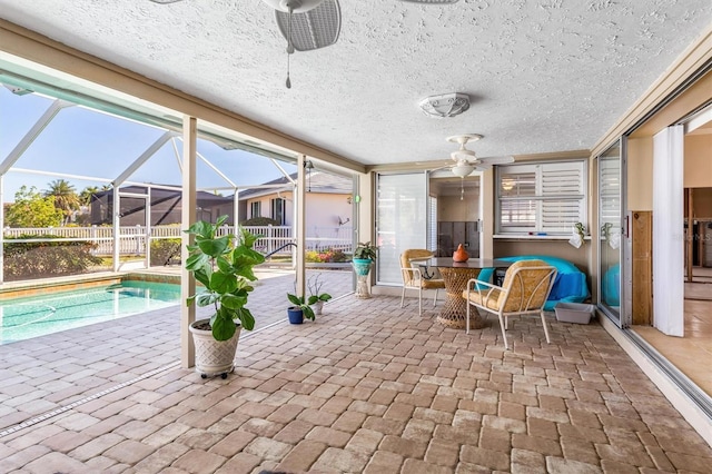 unfurnished sunroom with ceiling fan and a swimming pool