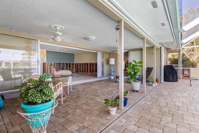 view of patio featuring a lanai and ceiling fan