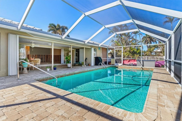 view of pool featuring a lanai, ceiling fan, and a patio area