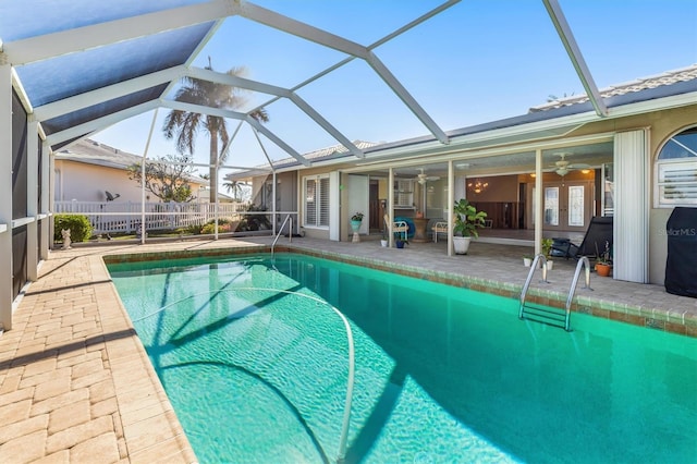 view of pool with glass enclosure, ceiling fan, french doors, and a patio