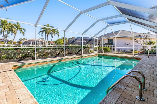 view of pool with glass enclosure and a patio area