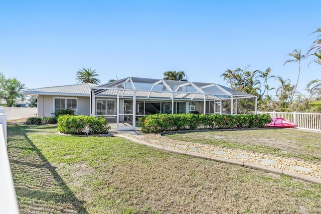 back of property featuring a yard and glass enclosure