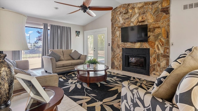 tiled living room with a fireplace, ceiling fan, plenty of natural light, and lofted ceiling