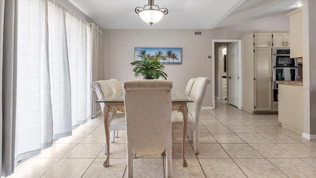 tiled dining room with vaulted ceiling