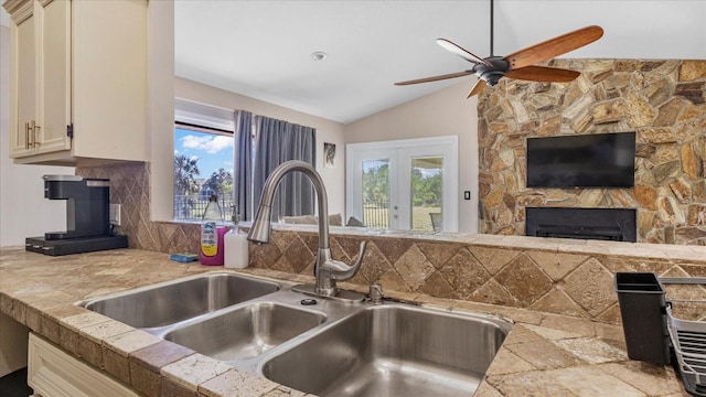 kitchen featuring decorative backsplash, sink, a healthy amount of sunlight, and lofted ceiling