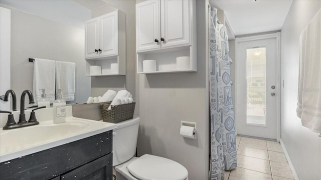 bathroom with toilet, vanity, and tile patterned floors