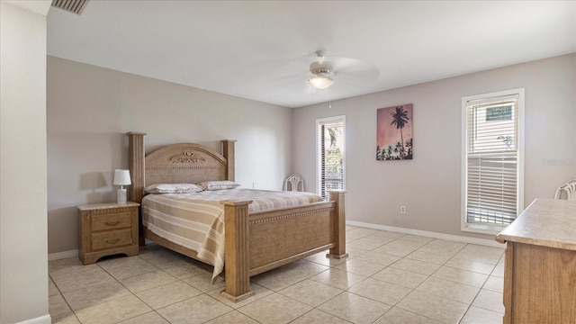 bedroom with multiple windows, ceiling fan, and light tile patterned flooring