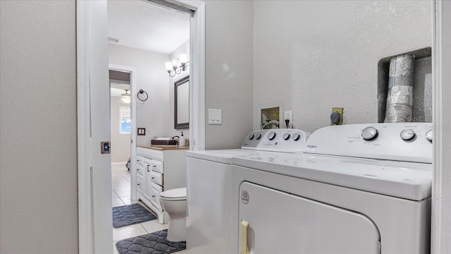 washroom with washer and clothes dryer and light tile patterned floors