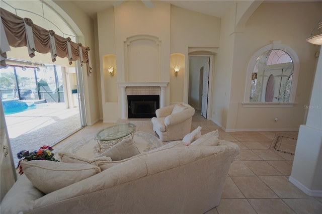 living room featuring a fireplace, light tile patterned floors, and high vaulted ceiling