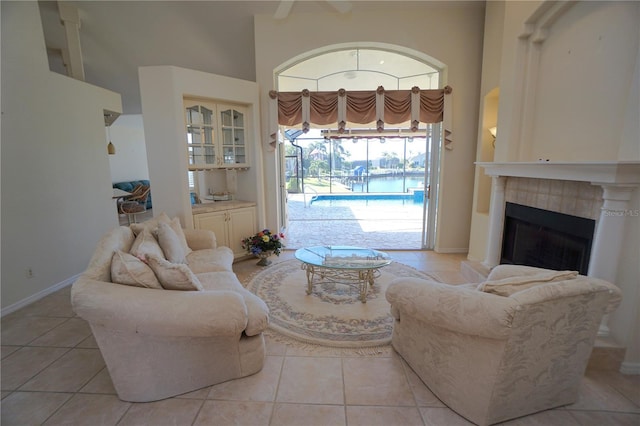 tiled living room with a fireplace and a high ceiling