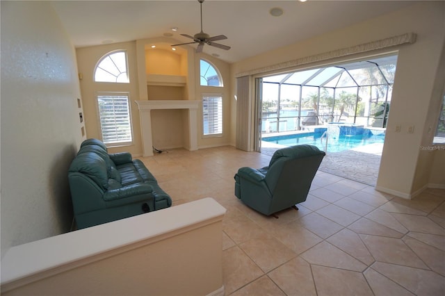 living room with ceiling fan, light tile patterned floors, and lofted ceiling