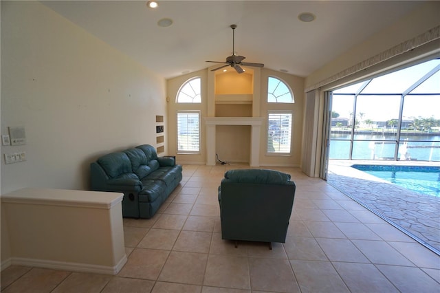 living room featuring a water view, ceiling fan, light tile patterned flooring, and lofted ceiling