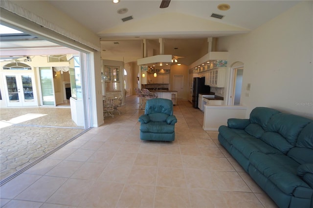 tiled living room with ceiling fan and vaulted ceiling