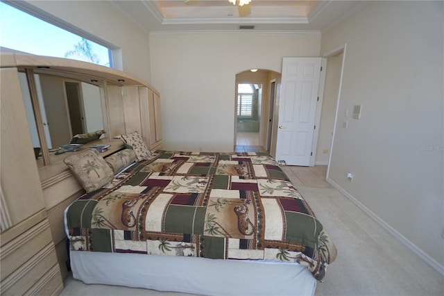 bedroom with a raised ceiling, crown molding, and light colored carpet