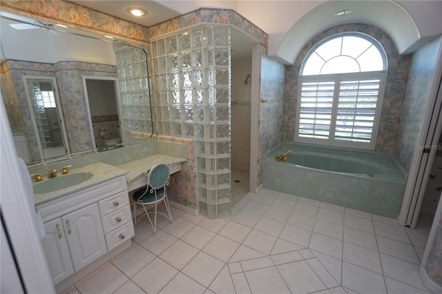 bathroom with tile patterned flooring, vanity, tile walls, and shower with separate bathtub