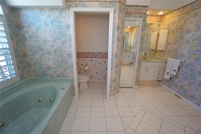 bathroom with tile patterned floors, vanity, toilet, and tiled tub