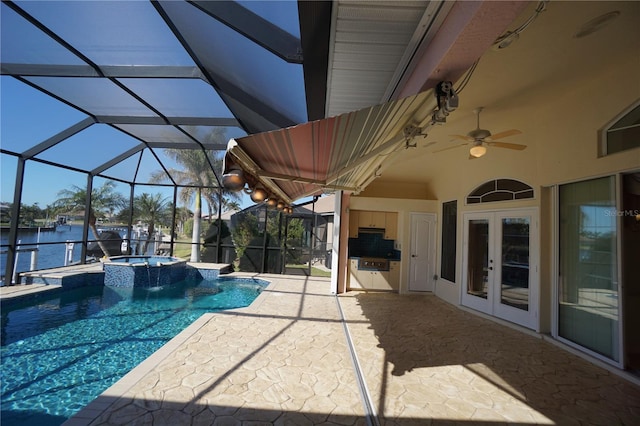 view of pool with french doors, a water view, ceiling fan, a lanai, and an in ground hot tub