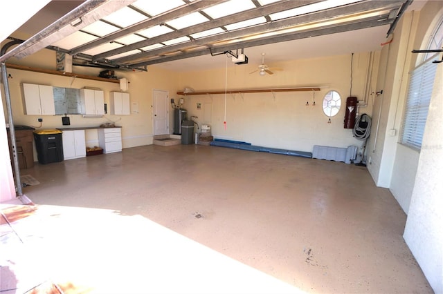 garage with ceiling fan, a garage door opener, and water heater