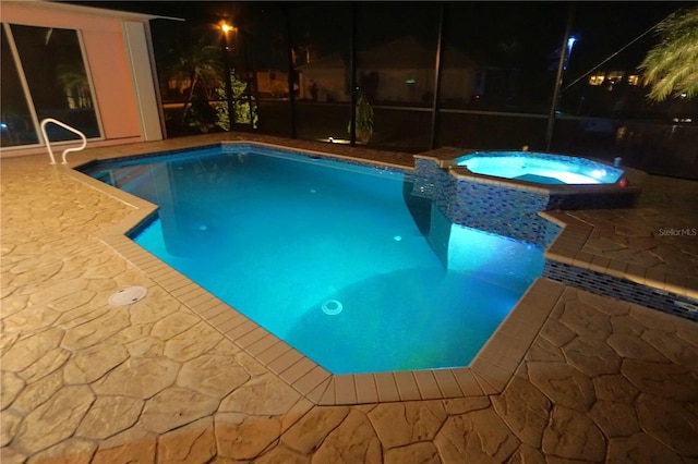 pool at twilight with a lanai and a pool with connected hot tub