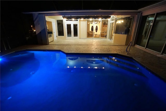 pool at twilight featuring french doors