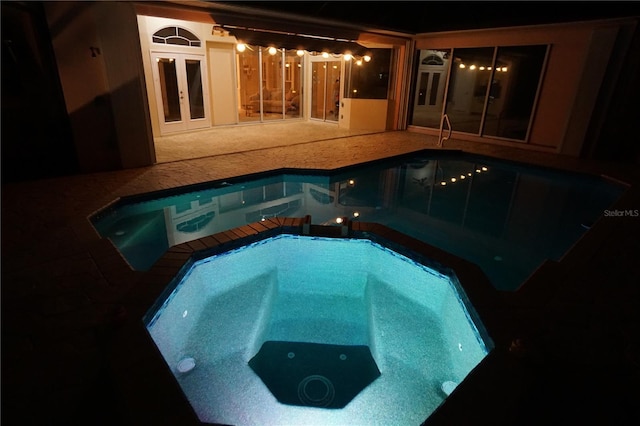 view of pool featuring french doors and a pool with connected hot tub