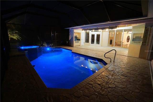 pool at twilight featuring glass enclosure, a patio area, and french doors