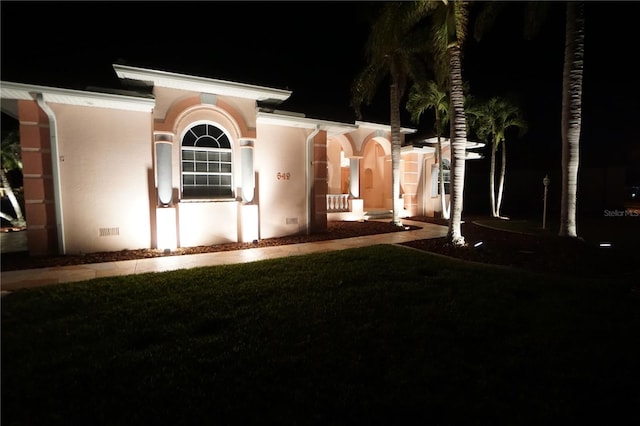 view of front of property with a yard, crawl space, and stucco siding