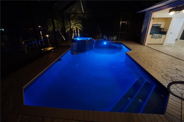 649 Maltese Dr, Punta Gorda, FL 33950 - pool at twilight featuring exterior kitchen, glass enclosure, a patio, and a pool with connected hot tub