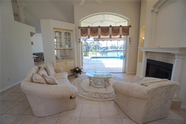 649 Maltese Dr, Punta Gorda, FL 33950 - living room with a towering ceiling, light tile patterned flooring, a tile fireplace, and baseboards