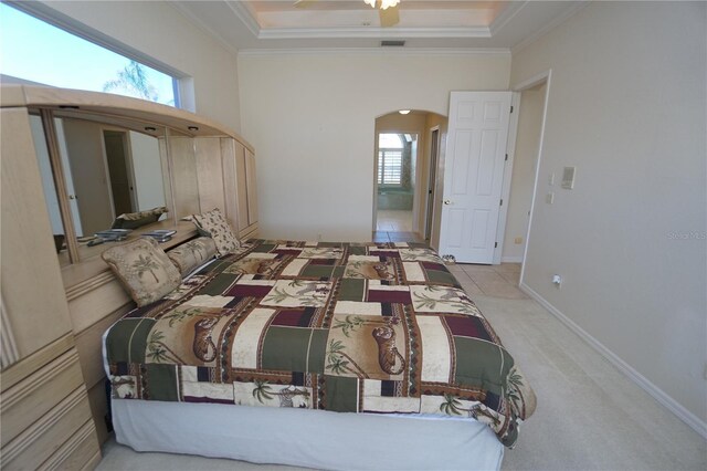 649 Maltese Dr, Punta Gorda, FL 33950 - carpeted bedroom with arched walkways, multiple windows, crown molding, a tray ceiling, and a ceiling fan