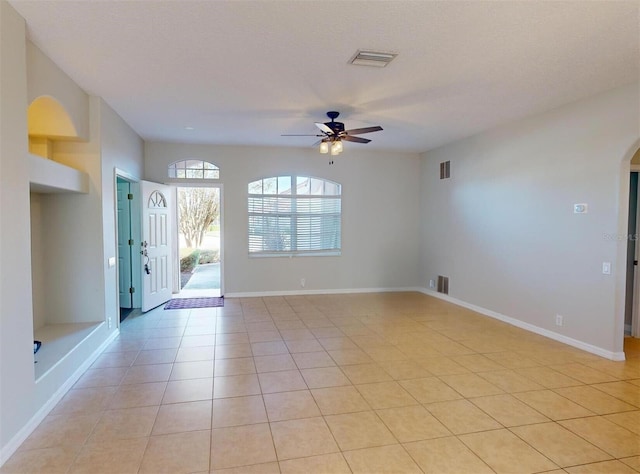 tiled spare room with ceiling fan