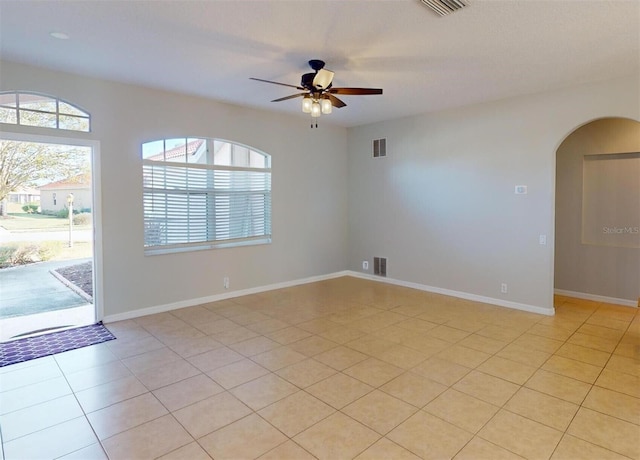 tiled spare room with ceiling fan