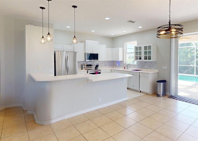 kitchen with decorative backsplash, appliances with stainless steel finishes, white cabinetry, and light tile patterned flooring