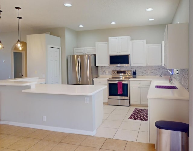 kitchen featuring sink, light tile patterned floors, appliances with stainless steel finishes, decorative light fixtures, and white cabinetry