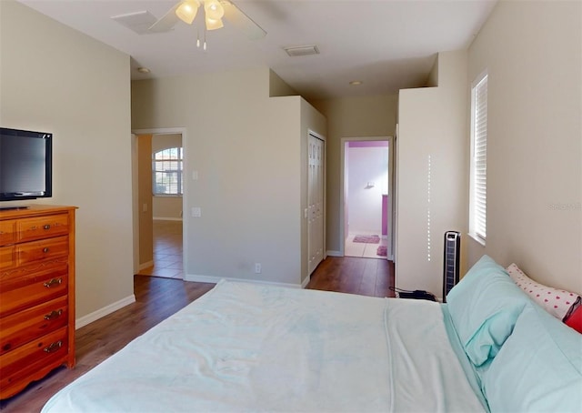 bedroom with ceiling fan, dark hardwood / wood-style flooring, connected bathroom, and a closet