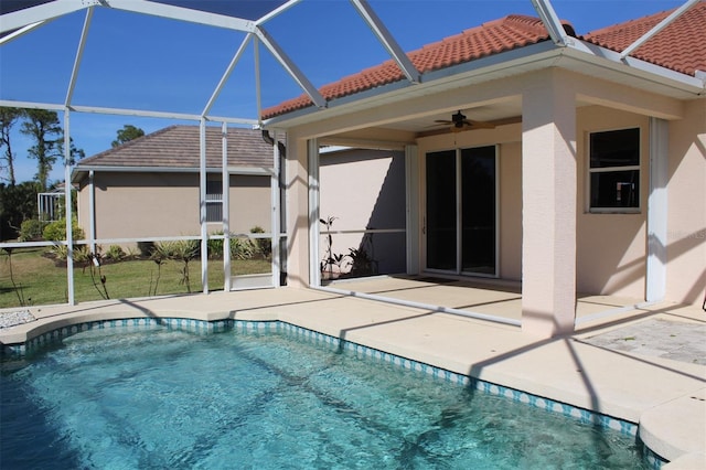 view of swimming pool featuring a patio, glass enclosure, and ceiling fan