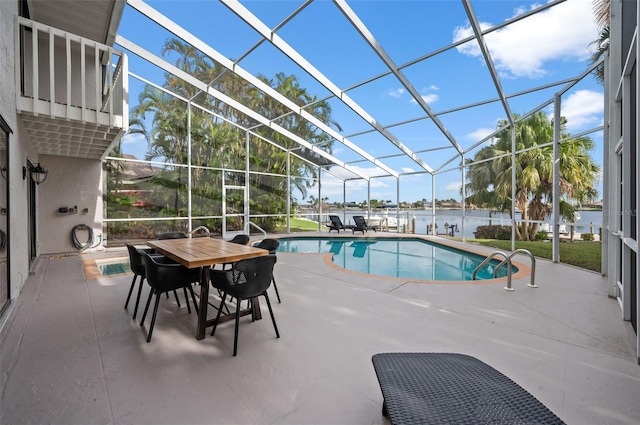 view of swimming pool with a patio, a water view, and a lanai