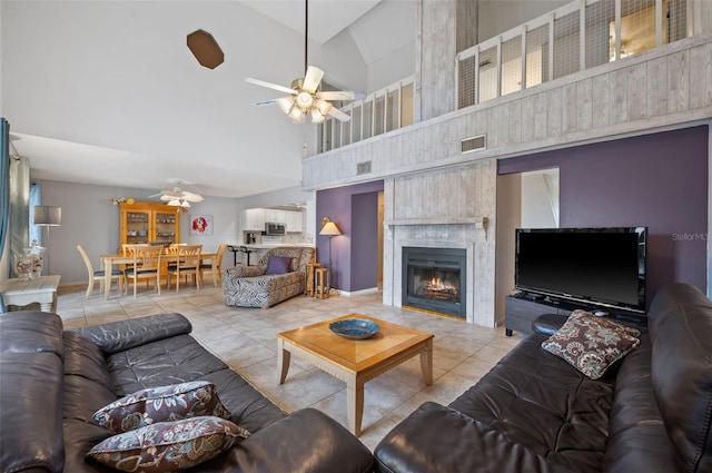 tiled living room with a fireplace, high vaulted ceiling, and ceiling fan