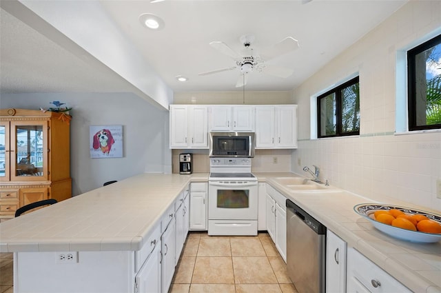 kitchen with white cabinets, tile counters, sink, and stainless steel appliances